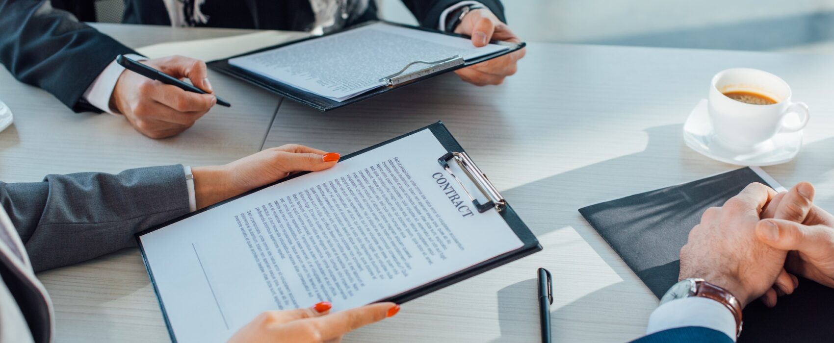 Cropped view of business partners holding contract on meeting in office. Translation services.