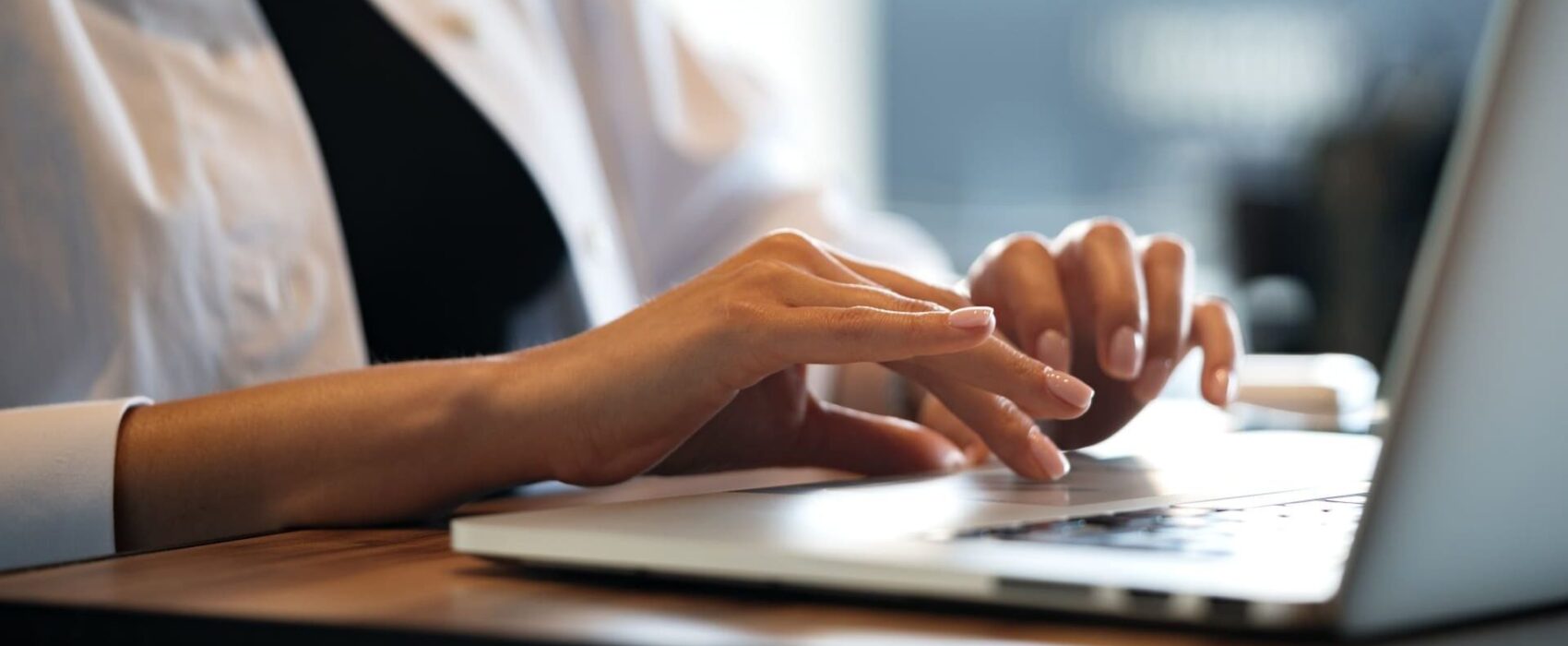 Close up of woman hands typing on laptop in cafe. Translation services.